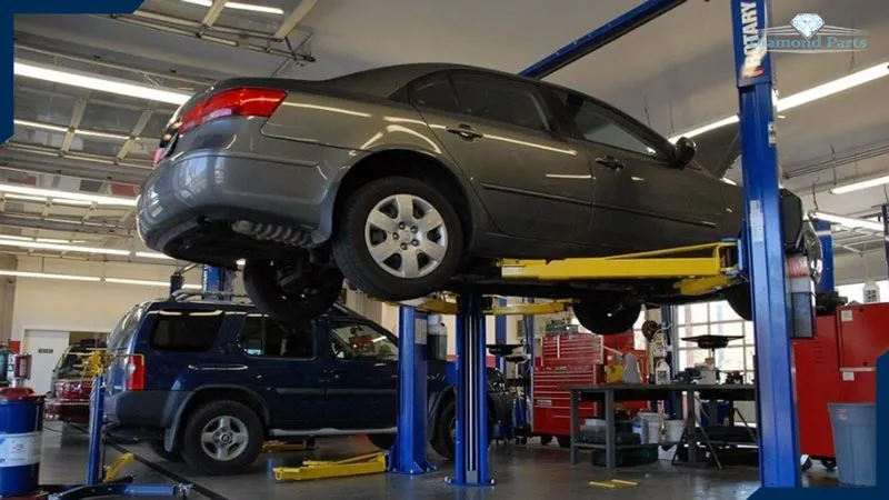 ماشینی که در تعمیرگاه، توسط جرثقیل بالا رفته تا تعمیر شود.